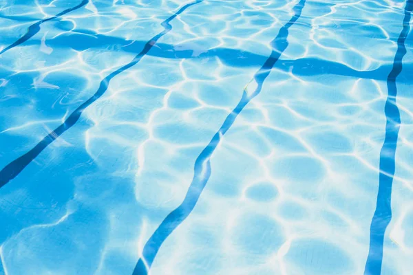 Літній день біля плавального басейну. Концепція тла і текстур. Брижі води в басейні зі відображення сонця. — стокове фото