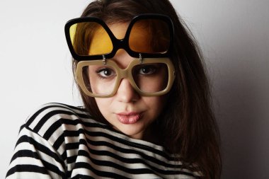 Çekici yakışıklı genç kadın boş arka plan üzerinde komik güneş gözlüğü takıyor. Güzellik ve moda kavramı.