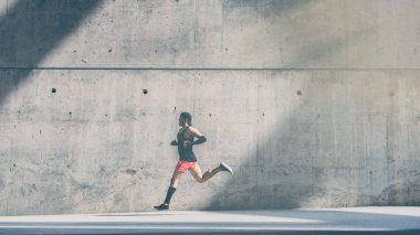 Hızlı koşma, açık havada egzersiz, kopyalama alanı alanı için metin mesajı veya reklam içeriği ile gri beton çerçevede dışında koşu kaslı erkek sprinter atlet. Yan görünüm, tam uzunlukta. Geniş.