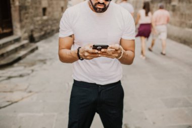 Akıllı telefon kullanan genç kentsel profesyonel adam. Yenilikçi iş arkadaşınız hareket eden smartphone güneş gözlüğü takıyor app mesaj sms mesajı kullanarak holding