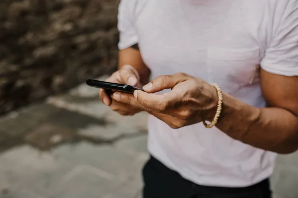 Bonito barbudo hispânico homem usando smartphone móvel para navegar na internet, fazendo chamada e olhando mapa da cidade digital. Masculino usando dispositivo eletrônico em viagens — Fotografia de Stock