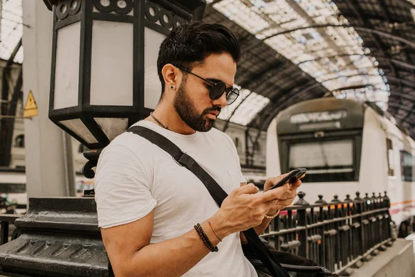 Empresário atraente enviando mensagem em seu telefone móvel.Empreendedor profissional casual usando smartphone no hall da estação ferroviária . — Fotografia de Stock