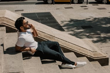 Yakışıklı sakallı İspanyol adam için dalga köpüğü hareket eden smartphone kullanarak Internet, web yapma çağrısı ve seyir dijital şehir haritası. Seyahat elektronik cihaz kullanarak erkek