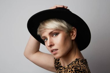 Headshot siyah şapkalı kameraya bakarak gülen mutlu sarışın kız portresi. Beyaz arka plan. Profil görünümü