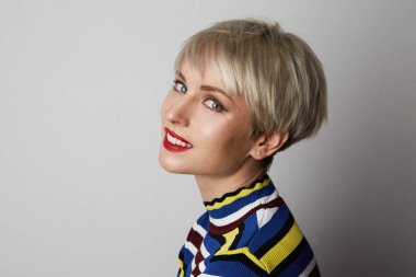 Kameraya bakarak beyaz boş arka plan üzerinde kırmızı dudaklar ile genç mutlu şirin neşeli kız portresi.