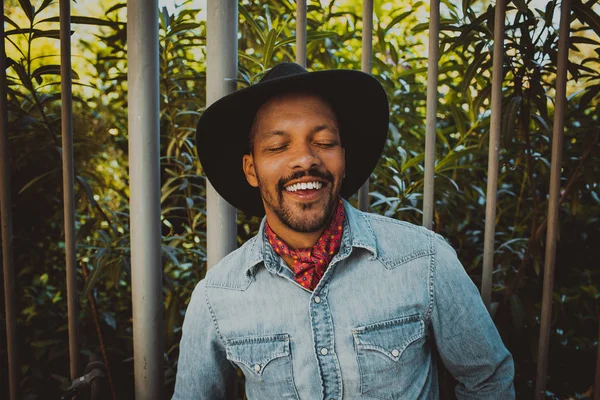 Happy attractive African American male hipster wearing black hat and jeans shirt. Street wear fashion black man . Lifestile concept.