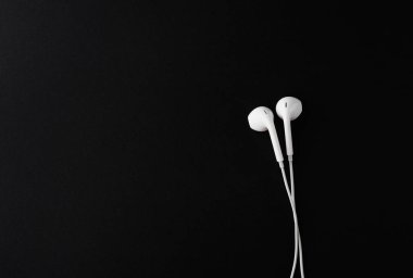 Siyah arka plan üzerine üstten görünüm beyaz kulaklık ya da kulaklık. Kopya hamur alanı.