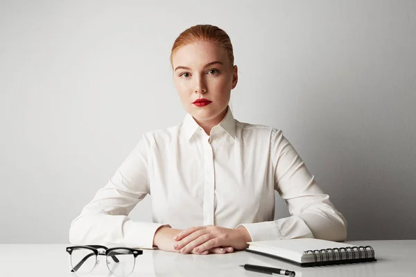 Charming redhead business woman working at the table over empty white background. — Stock Photo, Image