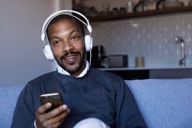 Telefonuna müzik dinlerken kulaklık ile çekici bir Afro-Amerikan adam. Gevşeme kavramı.