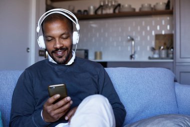 Telefonuna müzik dinlerken kulaklık ile çekici bir Afro-Amerikan adam. Gevşeme kavramı.