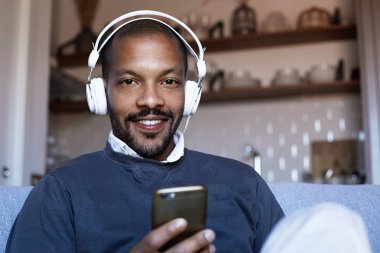 Kulaklıklar müzik yaptığı telefon dinlemek emin Afrikalı-Amerikalı adam. Gevşeme kavramı.