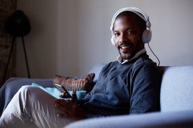Telefonuna müzik dinlerken kulaklık ile mutlu Afrika kökenli Amerikalı adam. Gevşeme kavramı.