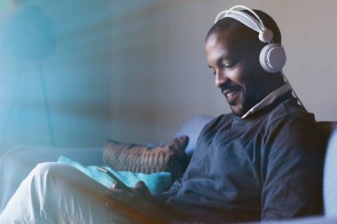 Telefonuna müzik dinlerken kulaklık ile çekici bir Afro-Amerikan adam. Gevşeme kavramı. İşaret fişeği.