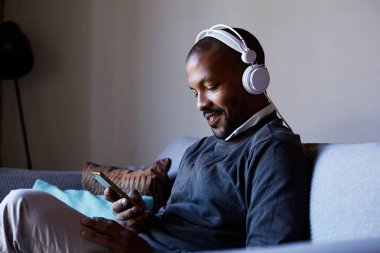 Telefonuna müzik dinlerken kulaklık ile çekici bir Afro-Amerikan adam. Gevşeme kavramı.
