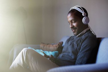 Telefonuna müzik dinlerken kulaklık ile çekici bir Afro-Amerikan adam. Gevşeme kavramı. İşaret fişeği.