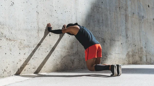 Corredor masculino haciendo ejercicio de estiramiento, preparándose para el entrenamiento matutino al aire libre. Amplio —  Fotos de Stock