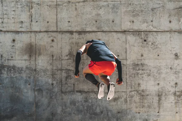 Hombre Hispano saltando. Ejercicio básico al aire libre. Ajuste atleta hombre ejercicio de fondo urbano . —  Fotos de Stock