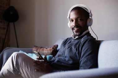 Çekici Afro-Amerikan erkek beyaz kulaklık müzik yaptığı telefon ile. Gevşeme kavramı.