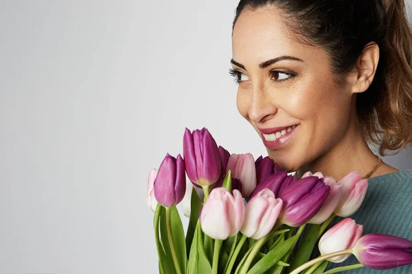 Portrait of happy girl with big bouquet flowers tulips in hands on a light background — Stock Photo, Image