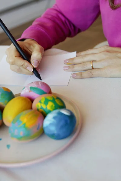 Happy easter. Young woman painting easter eggs. Happy family preparing for Easter
