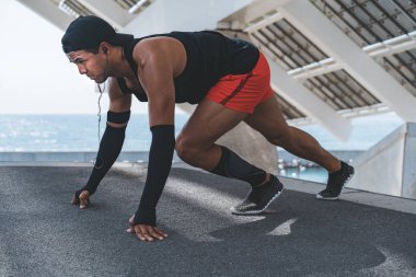 Erkek koşucu germe egzersiz yapmak için sabah idmanları açık hazırlanıyor.