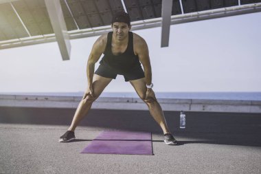 Kaslı erkek atlet sprinter germe egzersiz, açık havada egzersiz, dışarıda koşu yapıyor. sağlıklı yaşam tarzı.