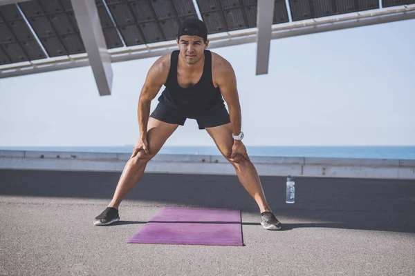 Masculino atleta sprinter haciendo ejercicio de estiramiento, hacer ejercicio al aire libre, trotar fuera. estilo de vida saludable . —  Fotos de Stock