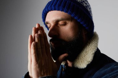 Dalgın sakallı adam portresi nefes beyaz arka plan üzerinde elleriyle ısınıyor. Stüdyo vurdu.