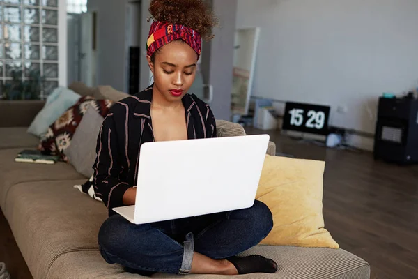 Koncentrovaná americké africké ženské blogger pracují vzdáleně na digitální netbook s textem internet. Africká žena textař psaní článku pro webové stránky na klávesnici moderní přenosný počítač doma — Stock fotografie
