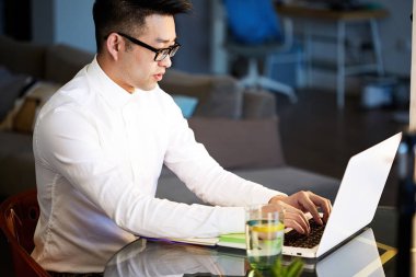 Genç Asya işadamı çalışma ile Laptop at ofis