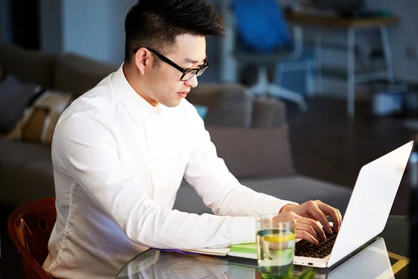 Jovem asiático empresário trabalhando com laptop no escritório — Fotografia de Stock