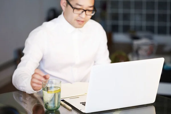 Jovem empresário asiático está trabalhando no laptop no escritório . — Fotografia de Stock