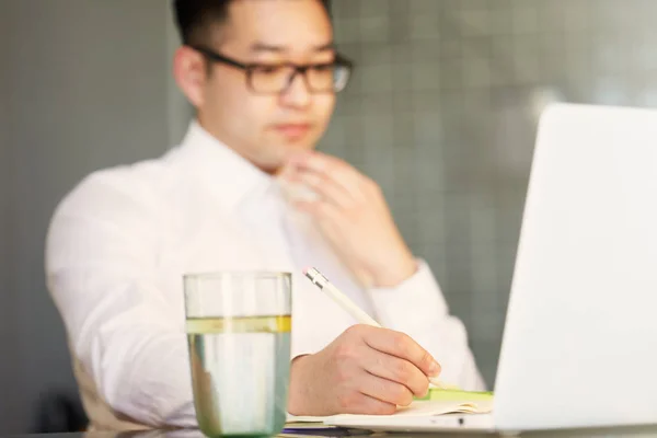 Giovane uomo d'affari asiatico sta lavorando su laptop in ufficio . — Foto Stock