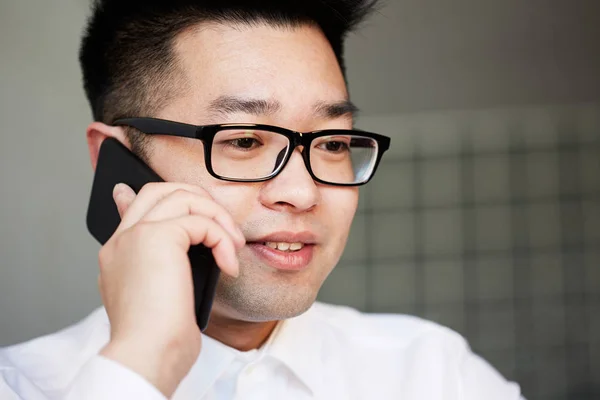 Empresário asiático falando no telefone celular no escritório — Fotografia de Stock