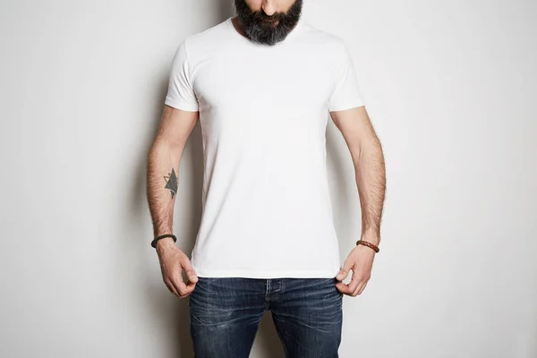 Modelo de homem muscular barbudo vestindo camiseta branca em branco com espaço para o seu logotipo ou design em estilo urbano casual no fundo branco . — Fotografia de Stock