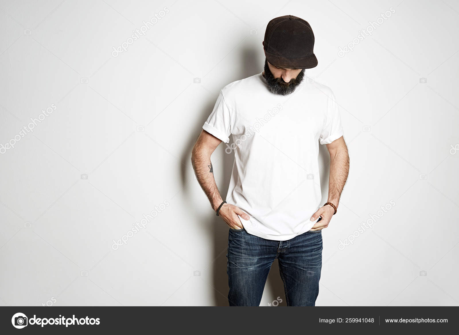 Download Brutal Attractive Bearded Biker Man With Tattooed Hands Poses In White Blank T Shirt From Premium Thin Cotton On White Mockup Background Stock Photo Image By C Eyecan 259941048