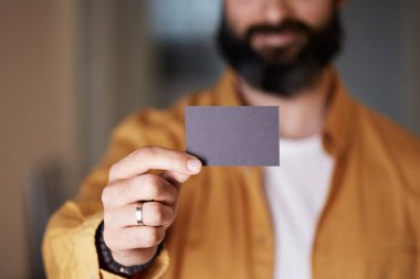 Sakallı girişimci bulanık arka planda el boş siyah kartvizit veriyor. Mockup Kopyala Yapıştır Boş Reklam.