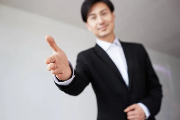 Confident young asian businessman offering handshake after business deal. Stock Photo