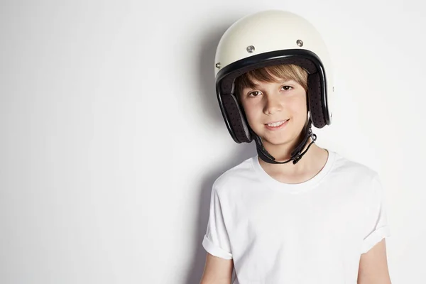 Sonriente joven lindo adolescente alegre en camiseta blanca draming a montar una motocicleta aislada sobre fondo blanco . — Foto de Stock