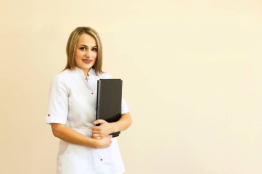 Kadın doktor Tekdüzen duran siyah bir klasörde ile gülümseyen