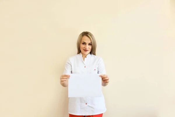 Nurse showing medical sign billboard standing in full length. Young smiling woman nurse or doctor in scrubs showing empty blank sign board with copy space. Asian model isolated on white background.