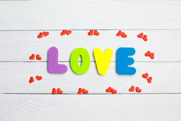Word Love on wooden background closeup. Concept for Valentines Day background.