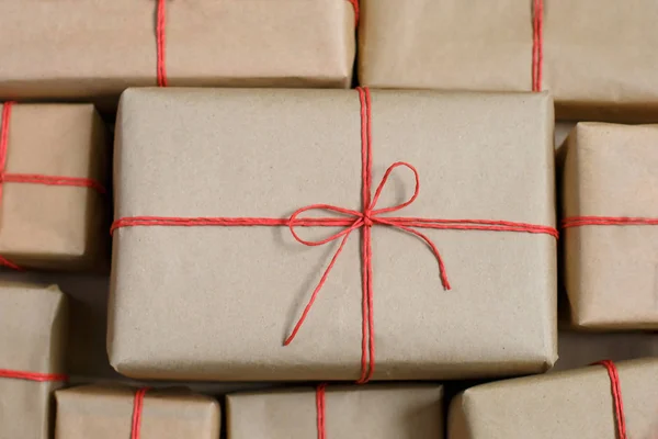 Подарки для друзей и семьи. Куча коробок. Выбор подарков в бумажной упаковке ручной работы и бантиках из красной бечевки . — стоковое фото