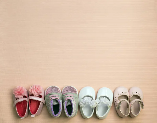 Beaucoup de chaussures de bébé mignonnes placées sur fond rose, vue de dessus — Photo