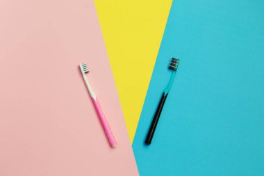 Sarı, mavi ve pembe arka plan üzerinde diş fırçaları. Diş Temizleme. Sağlık ve güzellik. Sağlıklı dişler.