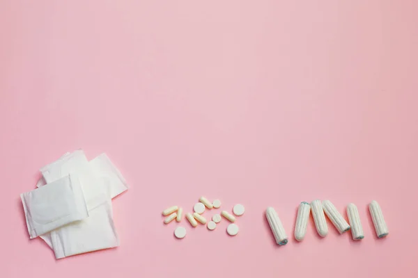 Almofadas sanitárias e folhas absorventes sobre fundo rosa — Fotografia de Stock
