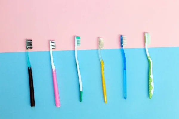 Toothbrushes on pink and blue background. Dental care. — Stock Photo, Image