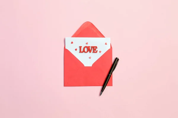 Envelop, rode harten en pen op roze achtergrond. Begrip van de liefde. Saint-Valentijnsdag — Stockfoto
