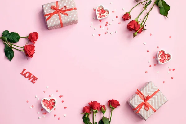 Día de San Valentín. Marco hecho de flores de rosas, corazones regalos sobre fondo rosa. Fondo día de San Valentín . —  Fotos de Stock