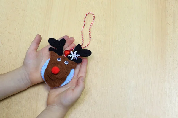 Kind zeigt ein Weihnachtsbaumspielzeug aus Filz. Kind hält ein Christbaumspielzeug in der Hand. Leichtes Winterbasteln und Aktivitäten für Vorschulkinder — Stockfoto